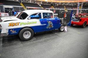 Classic blue and white vintage race car at an indoor event.