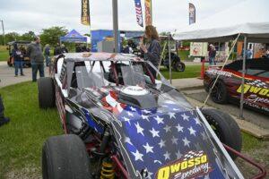 Race car with American flag design at outdoor event.