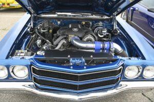 Close-up of a blue classic car engine and front grille.