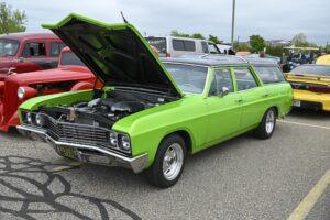 Bright green classic muscle car with hood open and polished engine.