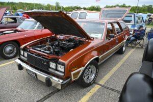 Classic brown station wagon with its hood open, showcasing the engine.