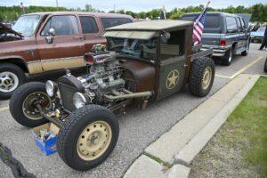 Custom vintage hot rod car with exposed engine and American flag.