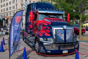 A large truck painted with red and blue flames, resembling Optimus Prime.