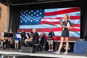 A band performing on stage with a large American flag backdrop.