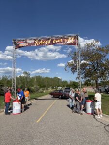 Participants gather at the finish line of a race event on a sunny day.