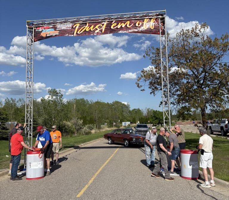 Participants gather at the finish line of a race event on a sunny day.
