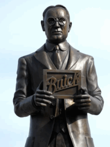 Bronze statue holding Buick sign.