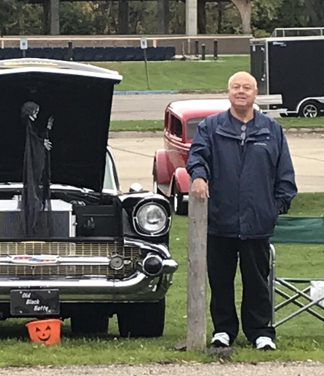 Man standing beside classic cars at show. Man standing beside classic cars at show.
