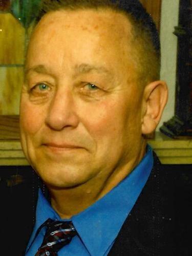 Smiling man in blue shirt and tie.
