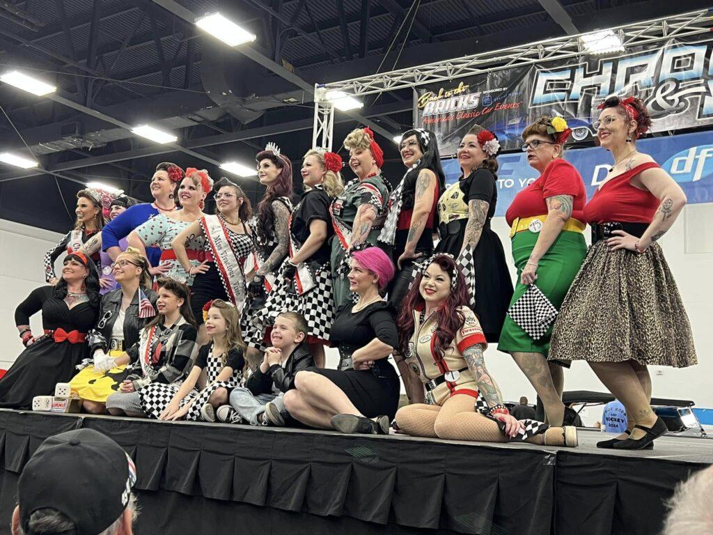 Group of women posing on stage, smiling.