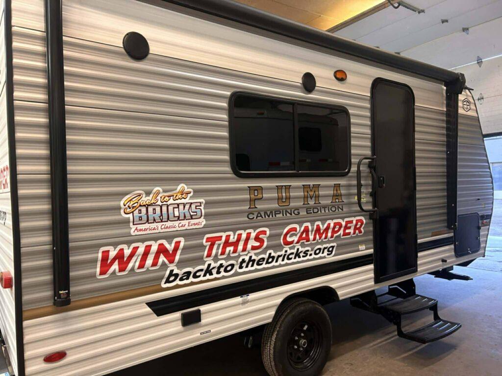 Camper trailer with contest advertisement text.