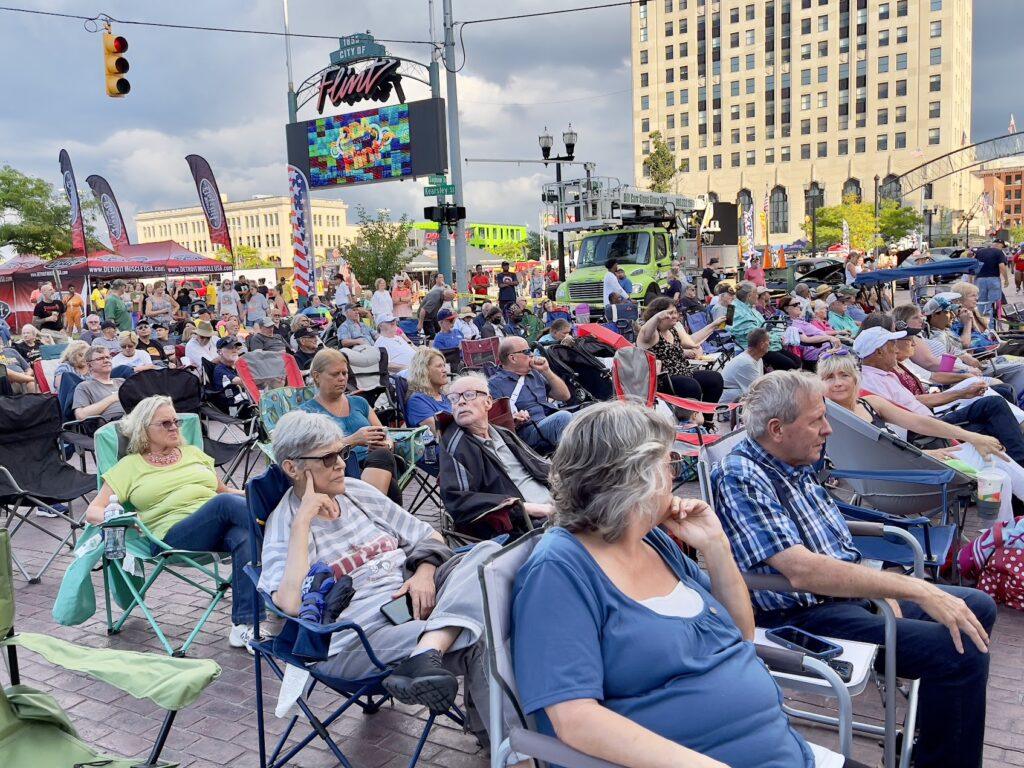Outdoor crowd seated for public event.