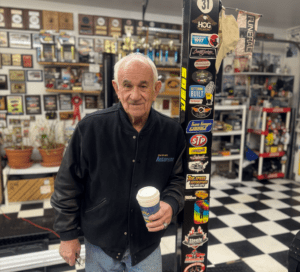Man holding coffee in a workshop.