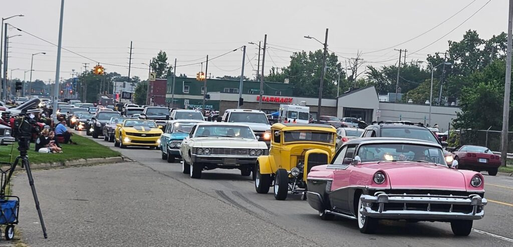 Classic cars driving in a parade procession.
