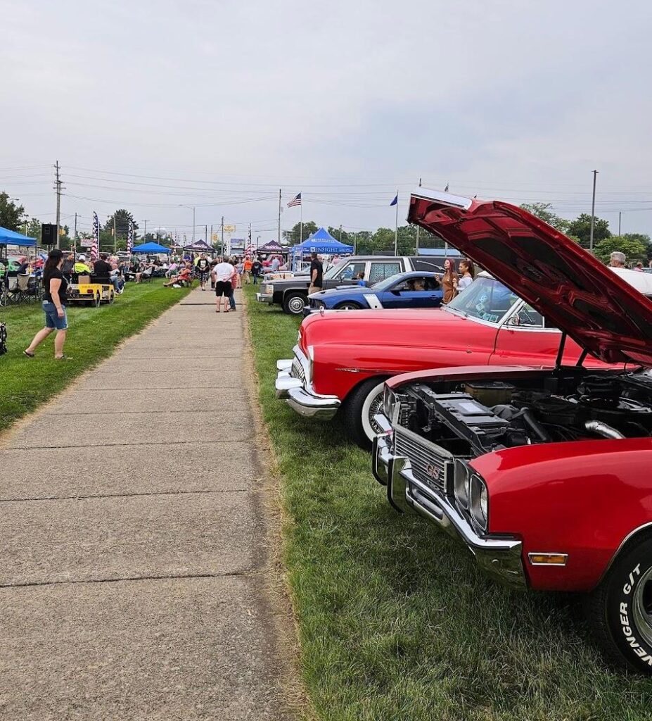 Classic cars displayed at outdoor car show.
