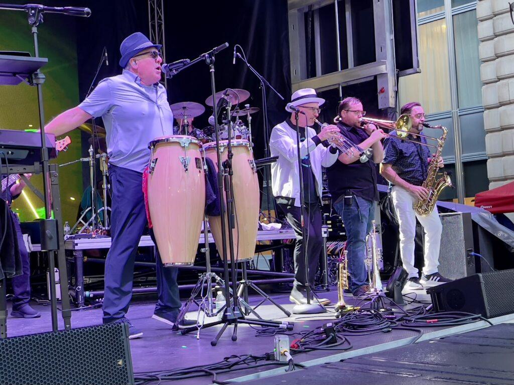 Band performing on stage with instruments.