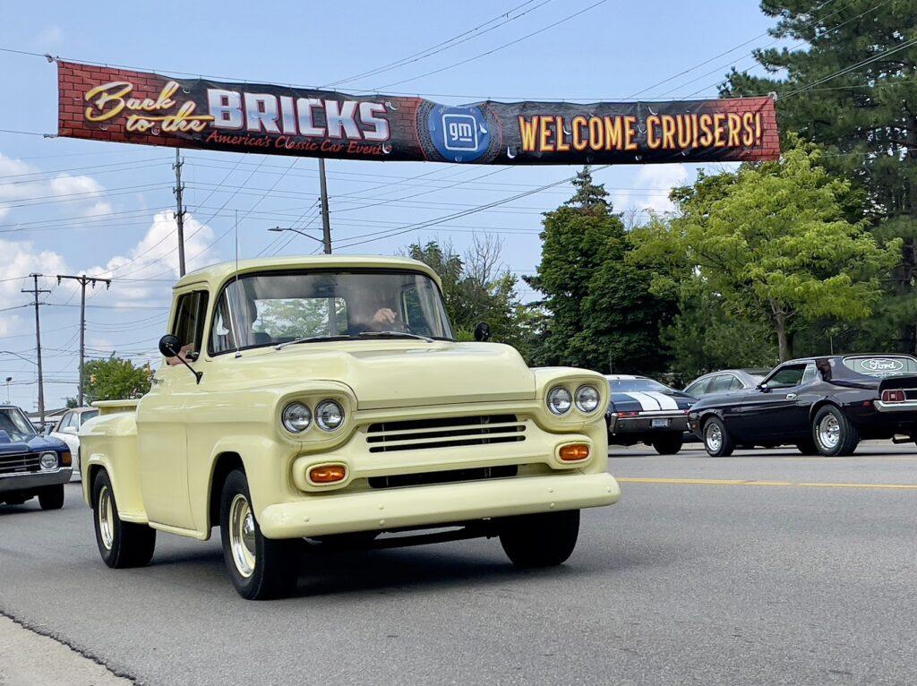 Vintage yellow truck at classic car event.