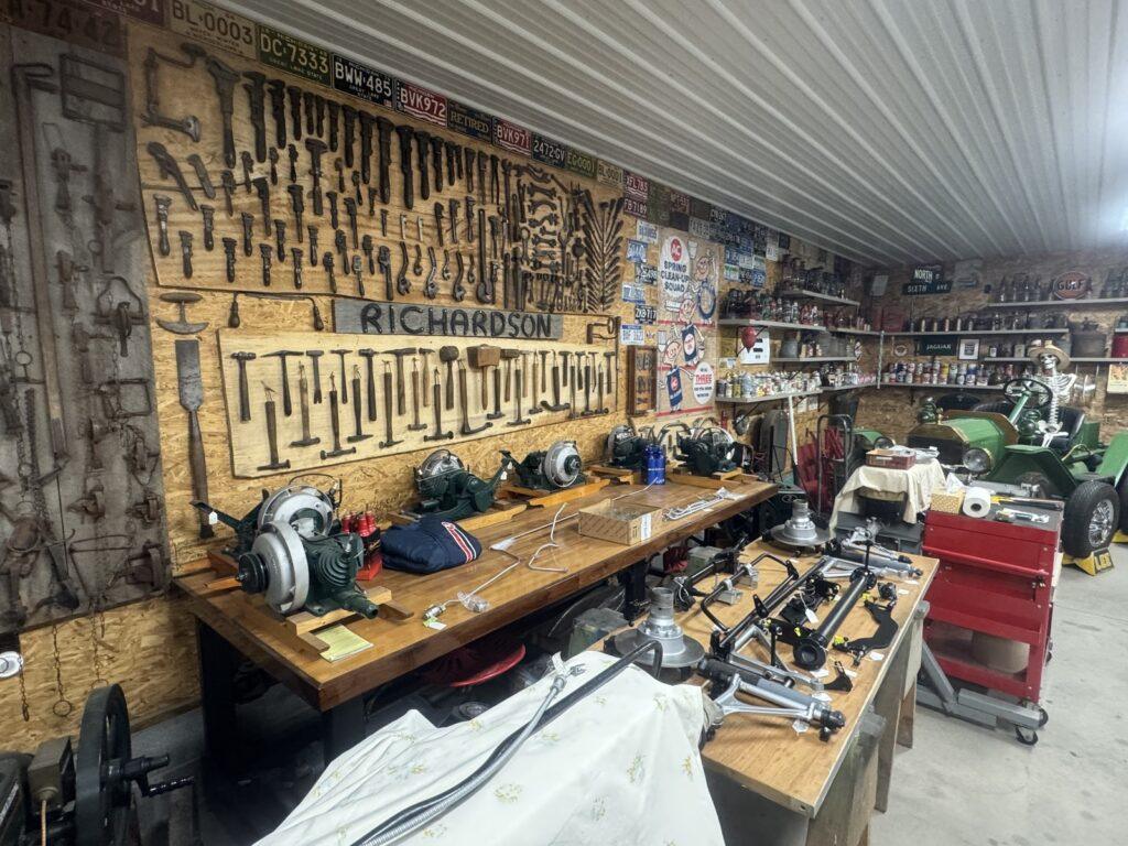 Workshop with tools and vintage signs displayed.