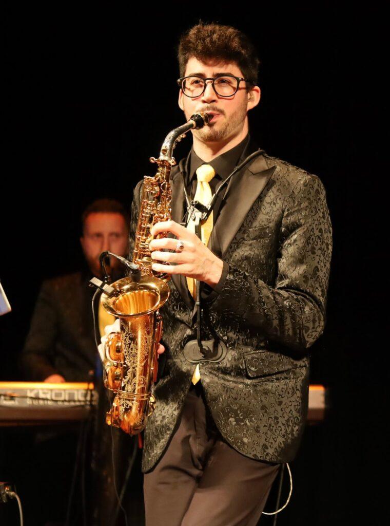 Man playing saxophone on stage performance.