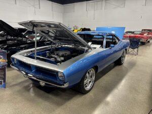 Blue classic car with open hood display.